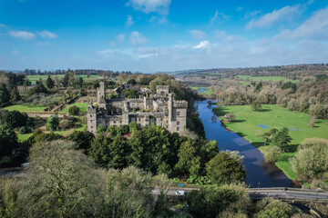 Aerial view of Lismore Castle, Ireland, showcasing its stunning Gothic architecture and scenic riverside location