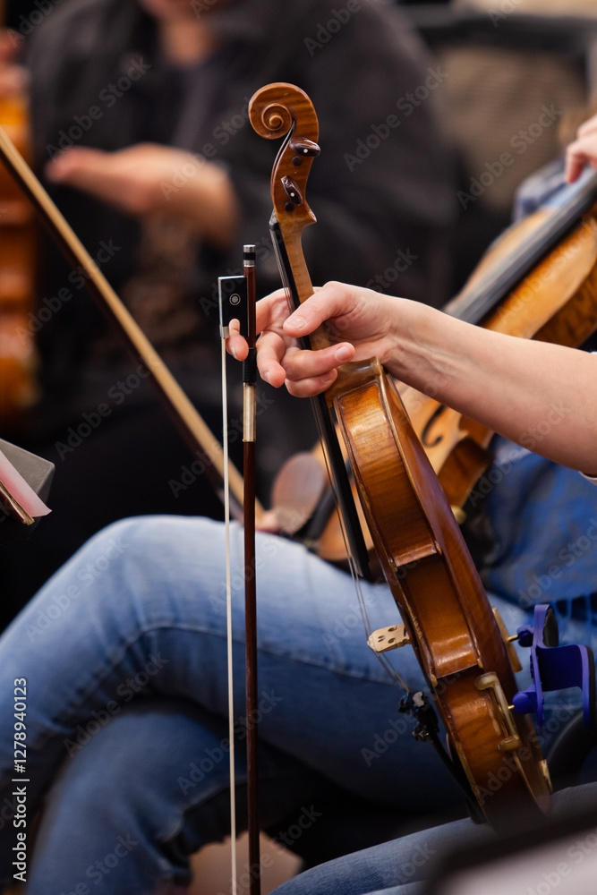 Wall mural A woman holds a violin during an orchestra rehearsal