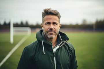 Portrait of a male coach of a school soccer team on field