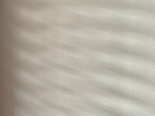 Naklejka premium brushed metal texture Light passes through the blinds and hits the cream-white wall, creating patterns and shadows.