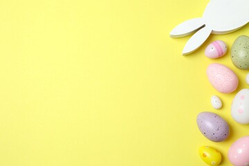 Happy Easter. Colorful eggs and bunny ears on color background, space for text or advertising