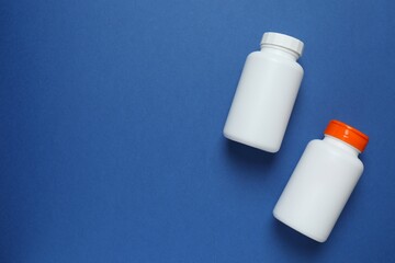 White bottles  on blue background, top view