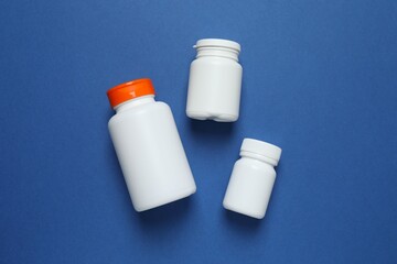 White bottles  on blue background, top view