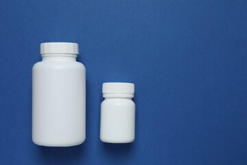White bottles  on blue background, top view