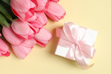 Beautiful fresh tulips with gift box on color background