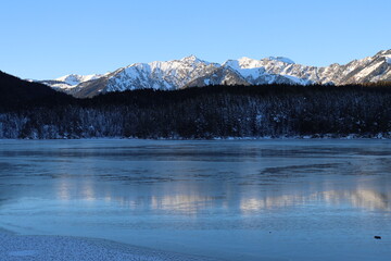 Reflection of the mountains in frozen lake