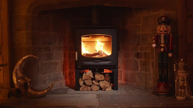 A fireplace with a large log in it and a nutcracker on a mantle. The fire is burning brightly and the room is warm and cozy