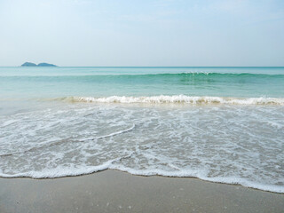 Fototapeta premium Gentle Ocean Waves on a Serene Sandy Beach.