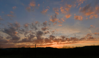 scenic panorama of the setting sun in a pink and light blue sky