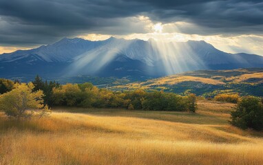 Obraz premium Sunlight pierces through clouds, illuminating a majestic mountain range, creating a stunning play of light and shadow in a breathtaking natural landscape.