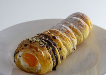 a delicious tube with whipped cream and fruit inside, sprinkled with powdered sugar and topped with...