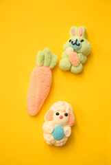 Cute Easter marshmallow figures—a lamb, a bunny, and a carrot—on a yellow background. Perfect for festive designs, greeting cards, and seasonal promotions.