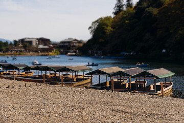 Arashiyama district panorama in western Kyoto, Japan, with boats and mountain Arashi, Togetsukyo bridge, Katsura Hozu River, autumn fall landscape view, travel to Japan, Kansai region, Kyoto