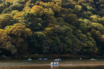 Arashiyama district panorama in western Kyoto, Japan, with boats and mountain Arashi, Togetsukyo bridge, Katsura Hozu River, autumn fall landscape view, travel to Japan, Kansai region, Kyoto