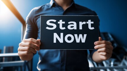 Man holding a sign that says "Start Now", symbolizing motivation and action