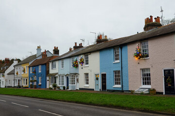 row of pastel coloured country cottages decorated with Christmas trees Alresford Hampshire England