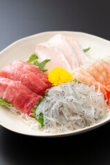 黒背景に刺身の盛り合わせ