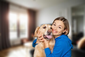 A young kind happy woman hugs cute dog.