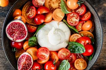 Delicious burrata cheese with fresh tomatoes, spinach, figs and olive oil.