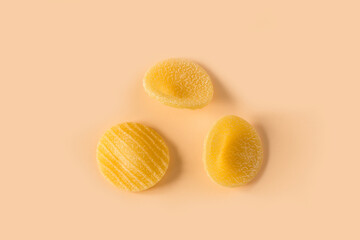 Orecchiette pasta isolated on light ochre background , top view . Macro shot of three isolated raw...