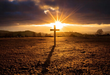A dark cloudy sky with golden rays breaking through, forming a subtle cross in the clouds.