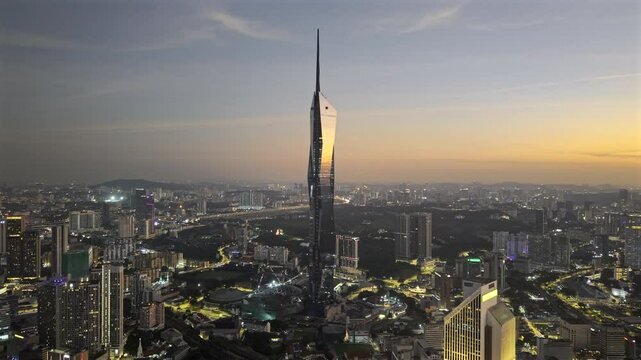 Merdeka 118 megatall skyscraper in Kuala Lumpur, Malaysia at sunset with the sun reflecting off the glass of the building (Aerial ProRes HDR drone video)