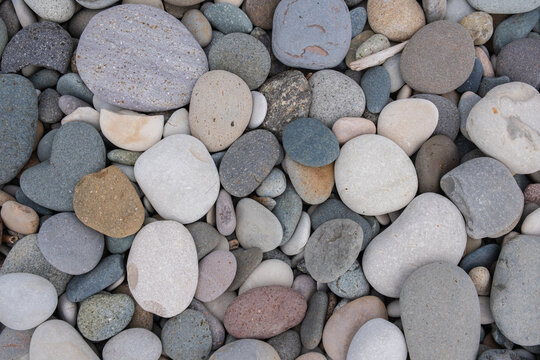 Colorful pebbles on beach. Textures and patterns of smooth round pebbles stones. Top view, close up