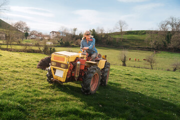 Obraz premium Female farmer driving a tractor in a green field, celebrating international workers' day