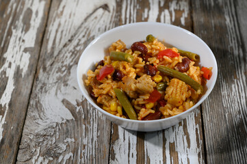 Savory rice medley with beans and vegetables in a rustic bowl on a wooden surface