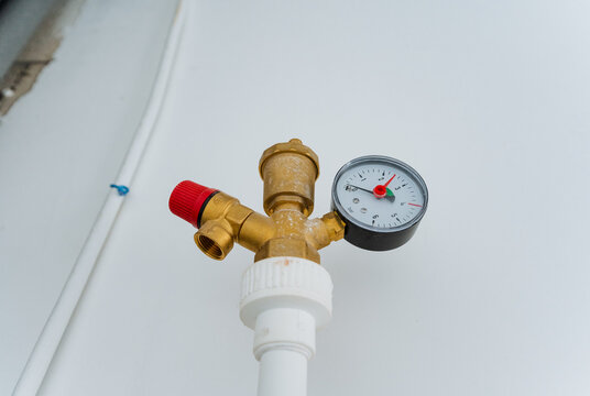 This is a detailed closeup view of a valve featuring a pressure gauge that is securely attached to it, allowing for precise measurement of pressure in a plumbing system or machine