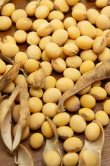 V&aacute;rios gr&atilde;os e vargens de soja espalhados sobre uma mesa de madeira.