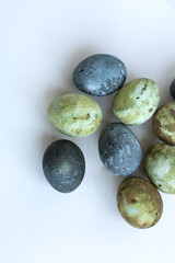 four Easter eggs painted in green-brown colors and Karkade tea, background