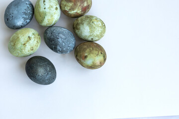 four Easter eggs painted in green-brown colors and Karkade tea, background