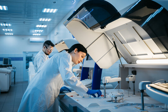 A scientist works with high-tech equipment in a modern laboratory, analyzing biological material and conducting experiments. Concept research of biological samples using cutting-edge technology.