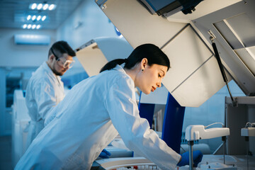 A scientist works with high-tech equipment in a modern laboratory, analyzing biological material and conducting experiments. Concept research of biological samples using cutting-edge technology.