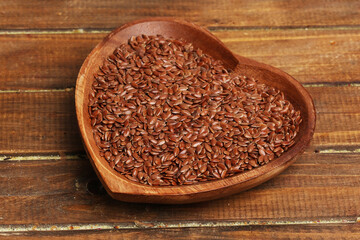 bowl with flax seeds on wooden background