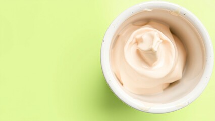 Creamy Beige Dessert in a White Bowl on a Light Green Background