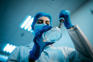 A specialist in a laboratory holds a liquid and analyzes it. The concept: utilizing high-tech methods for accurate analysis and scientific research.