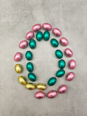 Colorful chocolate eggs forming an oval shape for easter celebration copy space