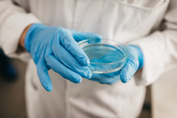 A specialist in a laboratory holds a liquid and analyzes it. The concept: utilizing high-tech...