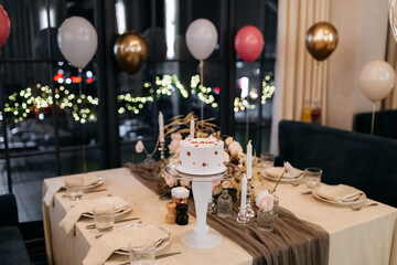Decor for a gender reveal party in a restaurant with flowers, balloons and cake. Oh baby party