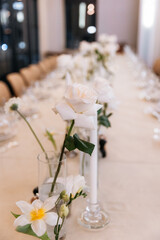 Decorated table with fresh flowers and serving with cake. Celebrating a party in a restaurant