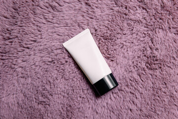White cosmetic tubes on textured pink animal fur. Cosmetics mockup.