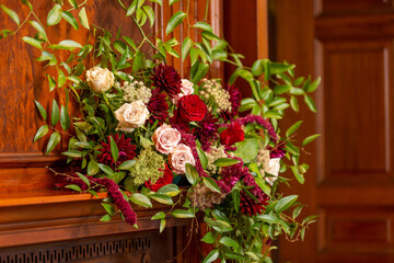 Artistic wedding flowers arranged on fireplace mantle 