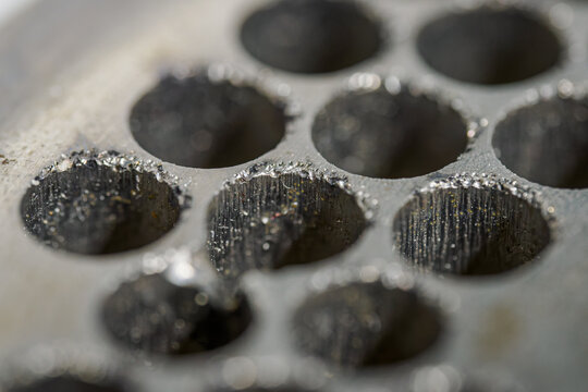 Detail of a damaged metal planchet from a grinder.

