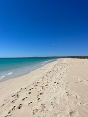 foot prints on a sandy beach and blue sky