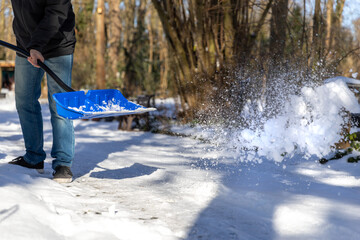 Schnee mit Schneeschieber auf einen Haufen werfen