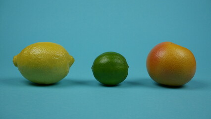 Lemon, lime and grapefruit on blue background. Citrus fruits line