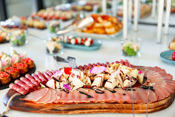 Exquisite charcuterie board adorned with vibrant garnishes at a lavish event celebration in a modern venue