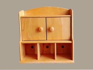 The gray background in the picture is a brown wooden wall mounted shelving unit that can be used as a multipurpose storage cabinet or medicine cabinet in the home. It has many compartments and is comp